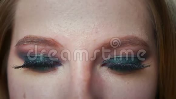 特写漂亮的白种人女人的步伐用化妆品的眼睛看镜头用美丽的自信室内视频的预览图