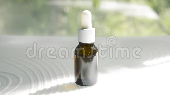 一个装有化妆品血清的深色玻璃吸管的玻璃瓶表面有条纹阳光照在上面视频的预览图