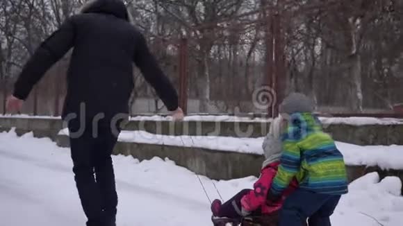 在寒假下雪的时候父亲在街上橇着孩子视频的预览图