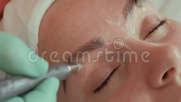 美容师的手在年轻女人的眼睛周围用电极微电流按摩做手术的漂亮女孩视频的预览图