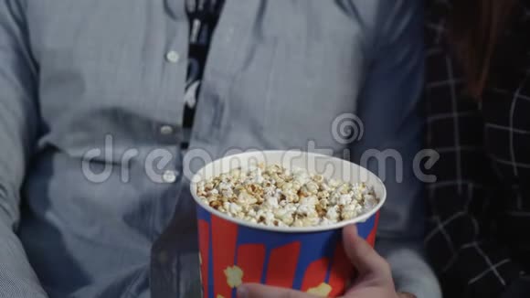 可爱的一对夫妇在电影院吃爆米花看电影视频的预览图