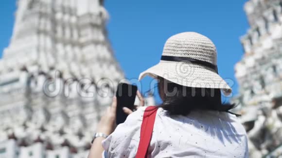 亚洲女士从智能手机上给WatArun拍照动作缓慢倾斜射击视频的预览图