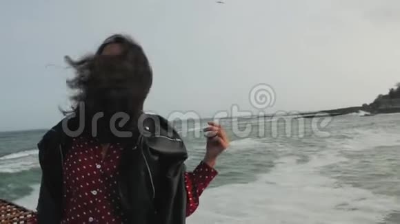 戴太阳镜的亚洲女孩在海边风吹发视频的预览图
