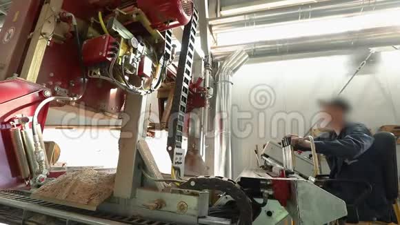 纵向锯木机上一个人在锯木厂控制锯子视频的预览图