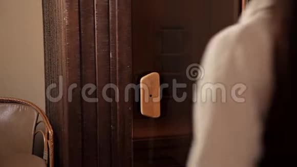 一个穿着白色长袍的年轻女孩打开玻璃门走进桑拿室视频的预览图