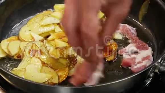 厨师把肉片放入锅中土豆用油煎视频的预览图