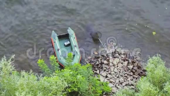 绿色划艇停泊在由岩石组成的岛上视频的预览图