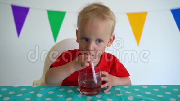 年轻的白种人男孩用吸管从杯子里喝苹果汁万向节运动视频的预览图