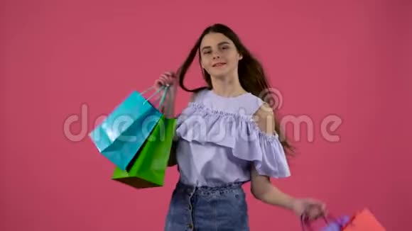 女孩从袋子里得到一只鞋很高兴粉色背景视频的预览图