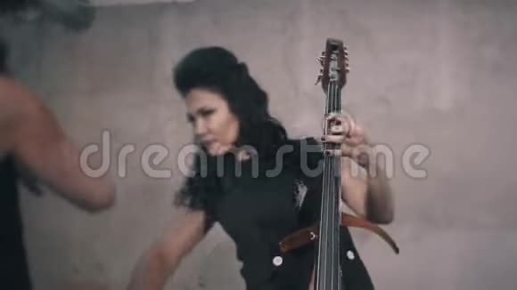 三个穿黑色衣服的小提琴手在一个未完成的房间里演奏视频的预览图