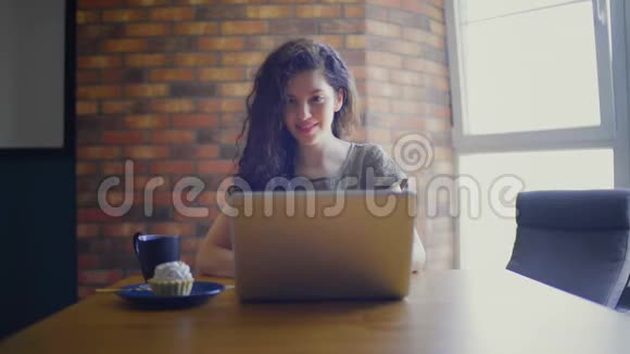 带蛋糕和茶的女人用笔记本电脑视频的预览图