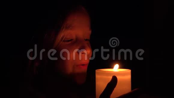 有蜡烛的快乐孩子夜晚的祈祷女孩黑暗中的孩子画像视频的预览图