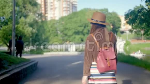 年轻的孕妇散步四处走动享受她的闲暇时间在公园一个夏天带图案的浅色长裙视频的预览图
