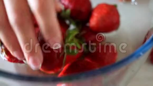 在一个玻璃碗里洗一大堆成熟的新鲜草莓视频的预览图