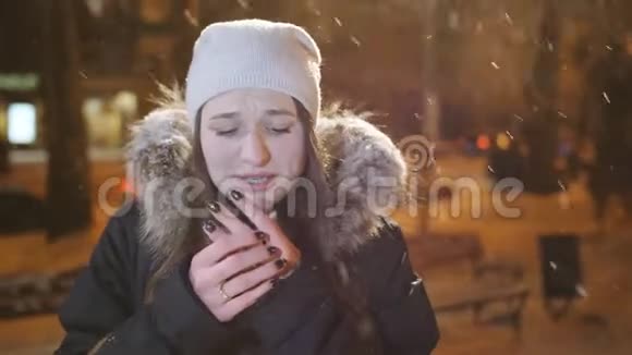 冬城傍晚少女画像一个女孩为降雪而高兴并温暖了他的手视频的预览图