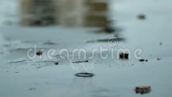 雨滴滴落在潮湿的水泥地上硬雨滴溅在水泥地面上视频的预览图