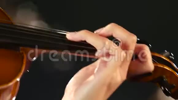 靠近一个小提琴女孩指着琴弦黑烟背景视频的预览图