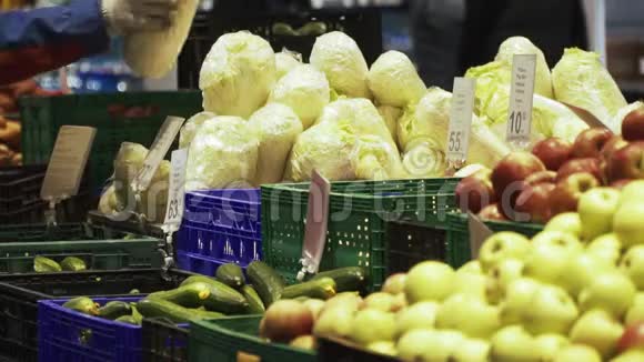 超市的工人们正在水果和蔬菜附近铺白菜视频的预览图