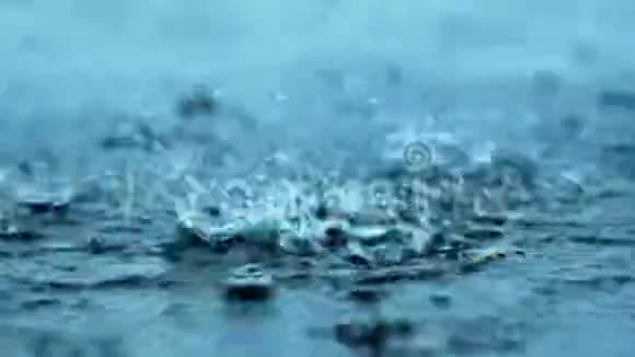 雨滴滴落在潮湿的水泥地上硬雨滴溅在水泥地面上视频的预览图