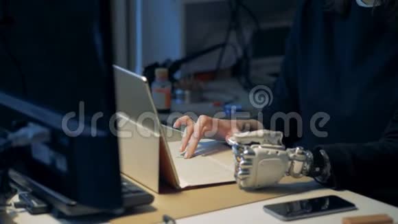 笔记本电脑上有仿生手型的残疾人金属假肢工作视频的预览图