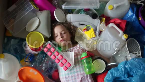 一个悲伤的女孩躺在一堆塑料垃圾里的肖像塑料是对环境的威胁塑料的问题视频的预览图