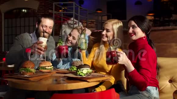 四个快乐的朋友在咖啡馆里喝着爽朗的鸡尾酒和柠檬水视频的预览图