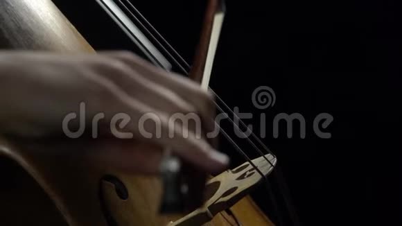 双手拿着笔记翻过背景片中大提琴的琴弦快关门侧视慢动作视频的预览图