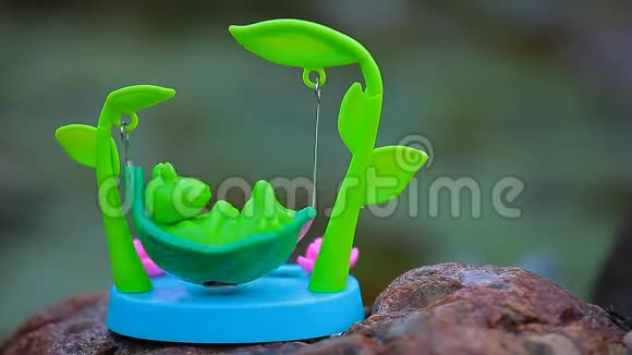 塑料青蛙吊床湖背景高清镜头视频的预览图