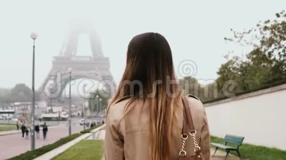 年轻快乐的女人走在法国巴黎市中心埃菲尔铁塔附近用手机交谈视频的预览图