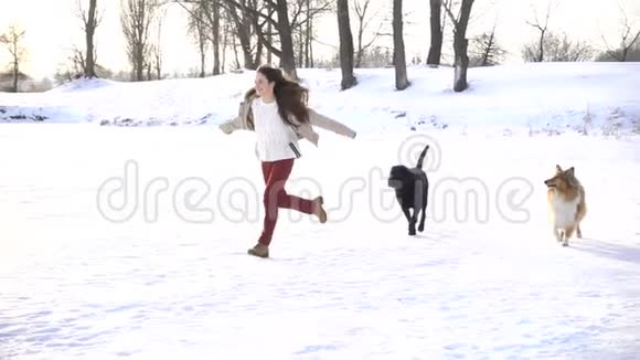 冬天雪地里和狗奔跑的女孩视频的预览图