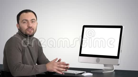 休闲商人微笑着对着镜头说话在渐变背景下的电脑显示器上显示一些东西视频的预览图
