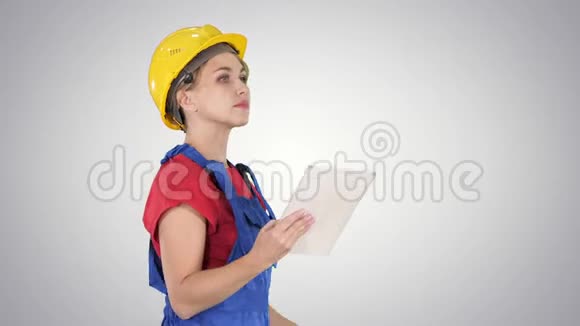 女建筑工程师在梯度背景上看平板电脑和检查对象视频的预览图