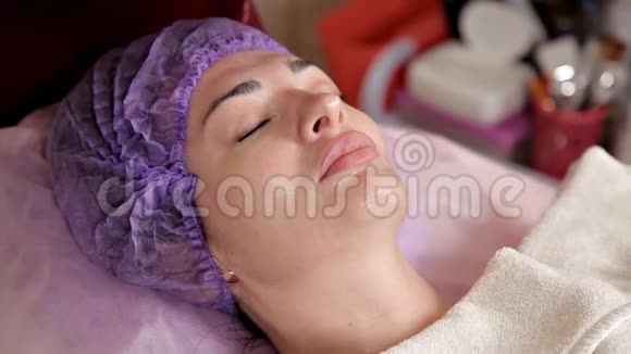 女性面膜抗衰老面部治疗美容师用刷子把保湿凝胶涂在脸上A视频的预览图
