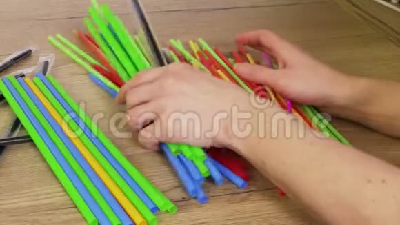 五颜六色的塑料吸管和手拢起来塑料污染概念视频的预览图