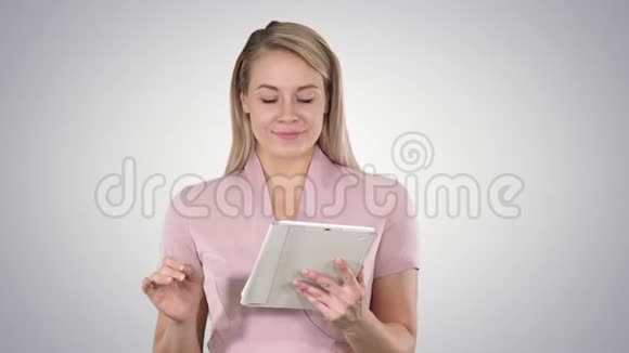 中镜头的美女使用平板电脑翻页并在的渐变背景视频的预览图