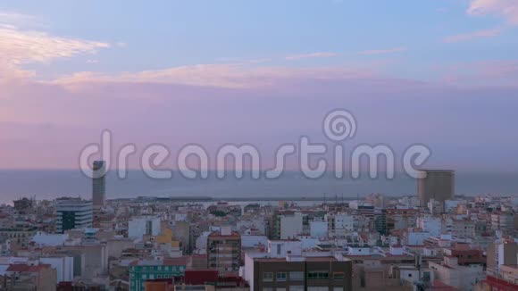 海边美丽的城市景观多云和紫色的天空一架飞机穿过云层离开城市视频的预览图