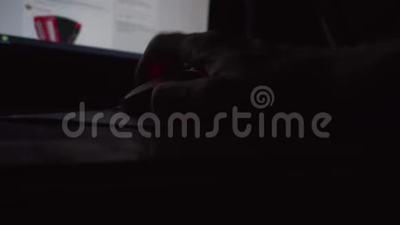 人的手在黑暗的房间里的桌面屏幕前滚动电脑鼠标视频的预览图