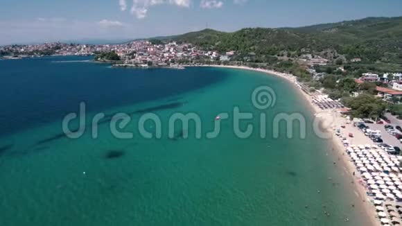 空中俯瞰美丽的海滩有山丘和一个旅游村NeosMarmarasHalkidiki希腊通过无人机前进视频的预览图
