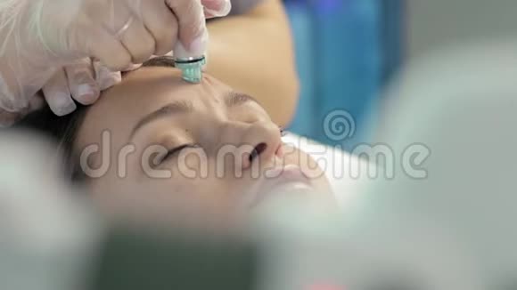 戴面膜的大师让她的年轻女性客户在水疗中进行面部真空剥离视频的预览图