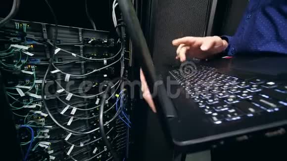 服务器块和一名IT支持工程师在其附近操作笔记本电脑视频的预览图