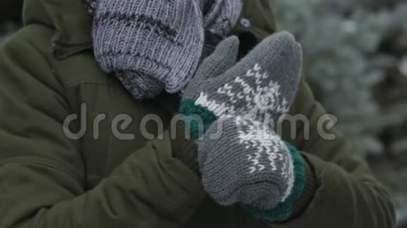 冬天森林里穿着毛皮手套的女人把手举起来美丽的风景雪杉树视频的预览图