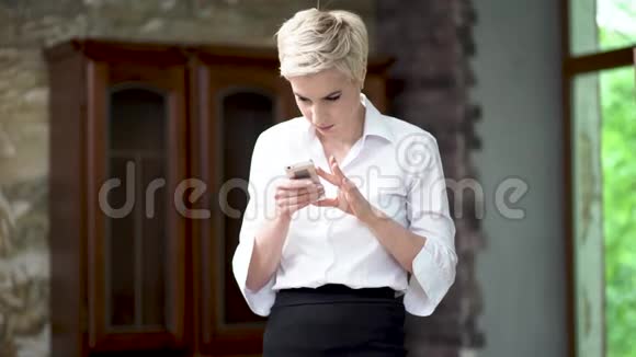 迷人的女商人一个人看着她的手机视频的预览图