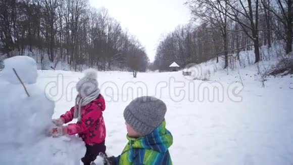 孩子们在寒假下雪的时候在雪地里堆雪人视频的预览图