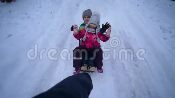 快乐的孩子在雪道上滑着雪橇手很快就带着雪橇视频的预览图