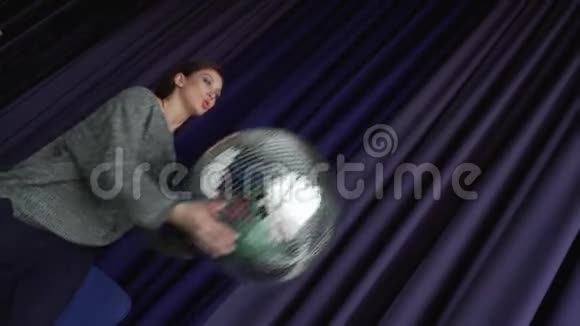 一个灰色的漂亮女孩手里拿着一个大迪斯科球视频的预览图
