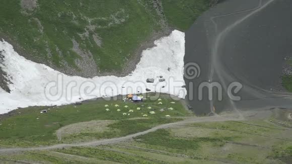 雪山的露营地坐在帐篷里的游客视频的预览图