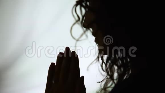 特写女人手牵手祈祷求神帮助祈祷剪影视频的预览图