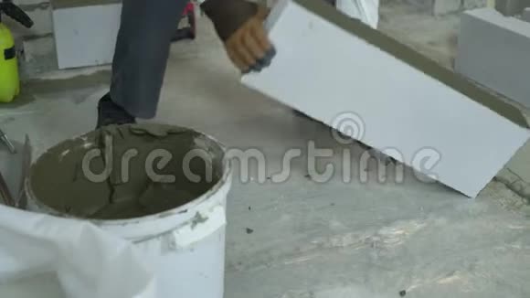 建筑工人将加气混凝土砌块铺设在水泥基础上视频的预览图