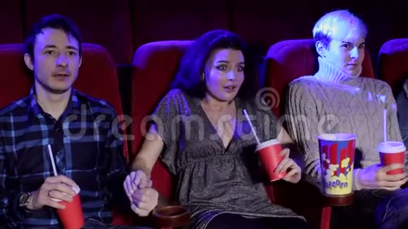 情感美丽的女孩和朋友在电影院看恐怖电影视频的预览图