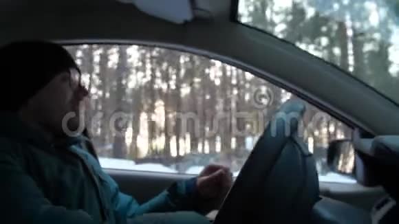 冬天男人开车男子手在汽车上扭轮视频的预览图